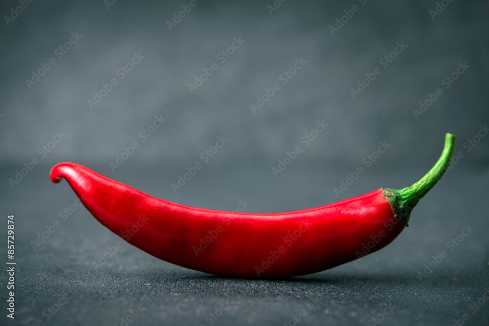 chili pepper on black stone background , smiling shape
