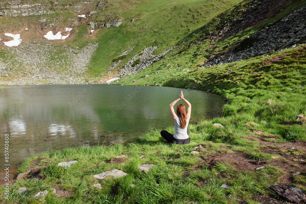 年轻女子在湖边做瑜伽练习
