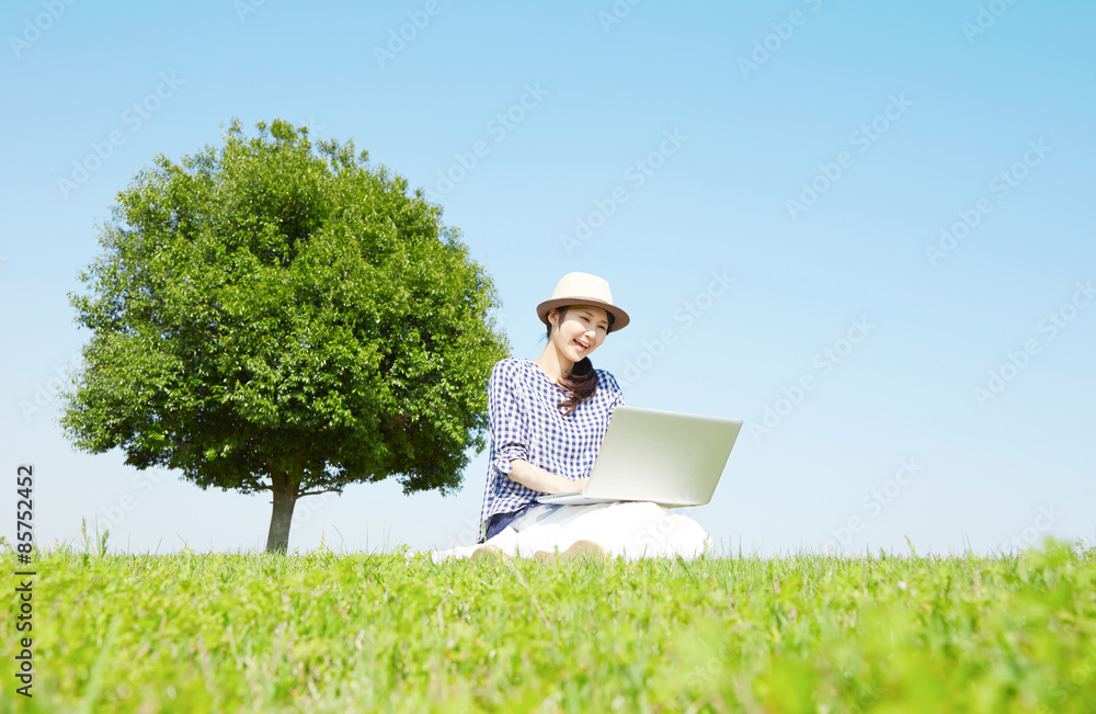 広場でノートパソコンを使う女性