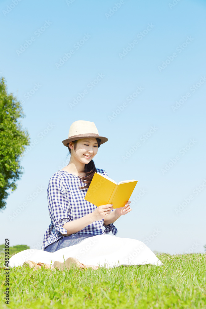 広場で本を読む女性