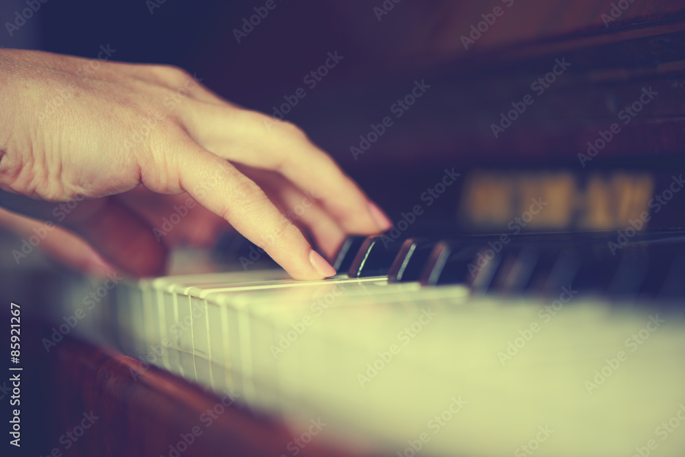 女钢琴家在钢琴键盘上的双手