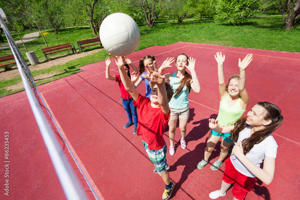 双臂向上的儿童玩排球