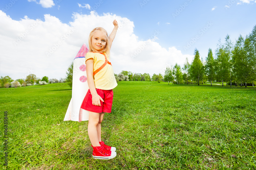 女孩肩上扛着火箭玩具，举起手臂