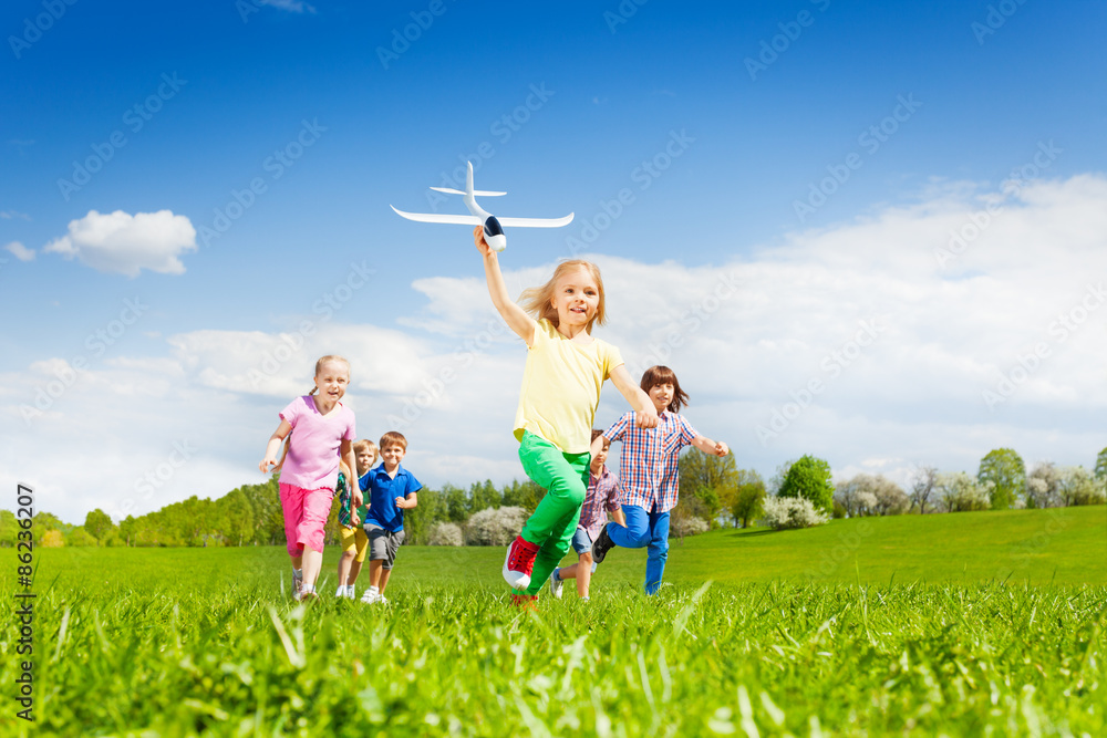 带着飞机玩具的女孩跑得很快，后面有孩子