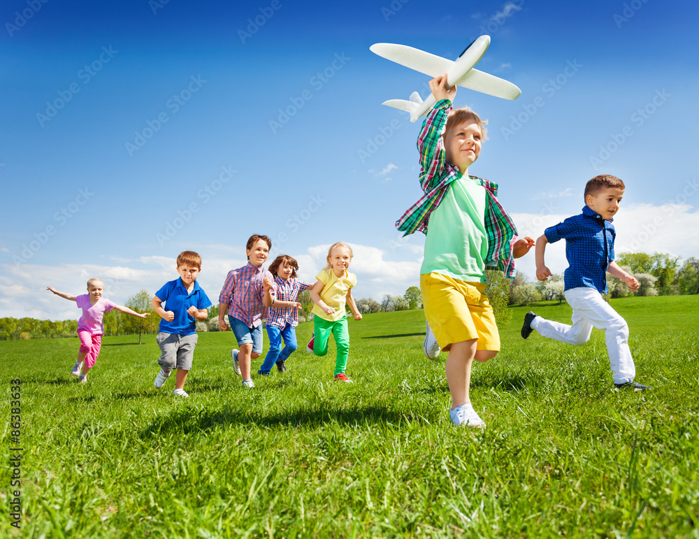 积极奔跑的孩子和男孩拿着飞机玩具