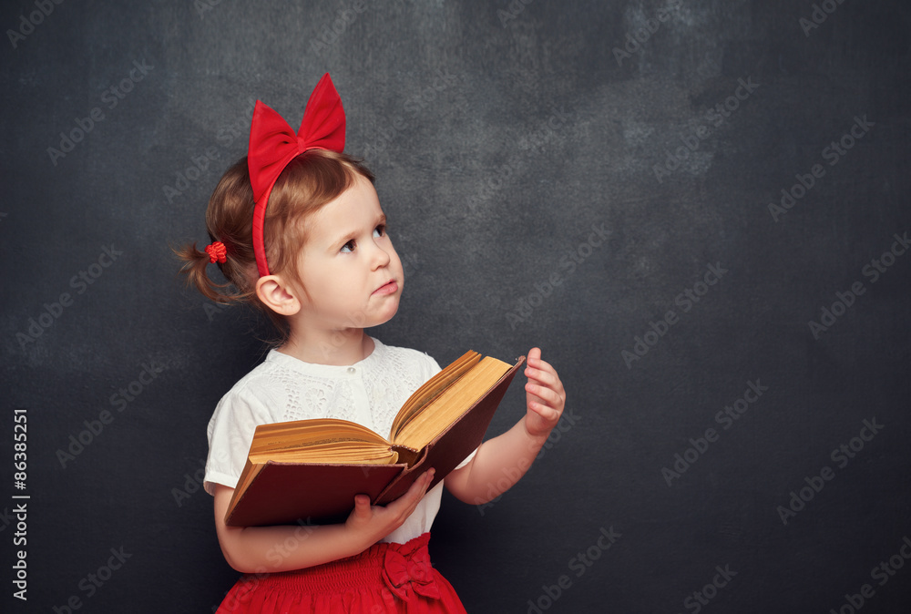 funny happy  girl schoolgirl with book from blackboard