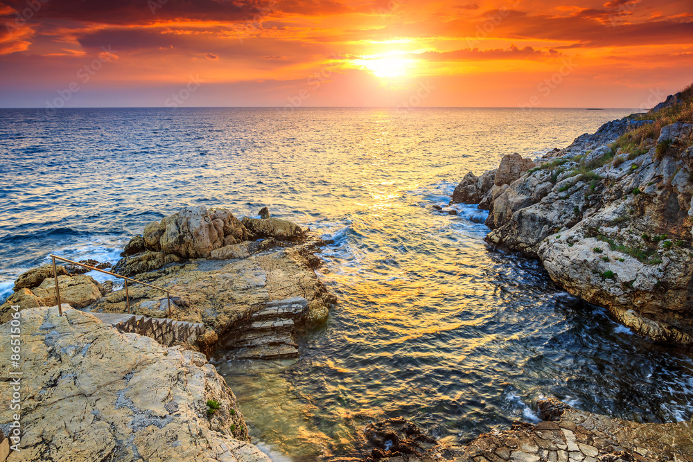 克罗地亚伊斯特里亚Rovinj附近令人惊叹的岩石海滩和美丽的日落