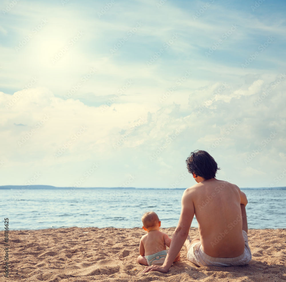 年轻的父亲和他的儿子在海滩上