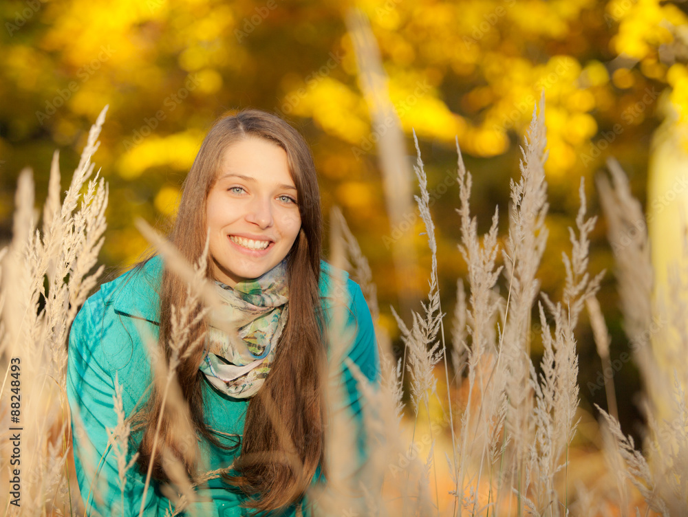 Beautiful girl portrait in autumn grass