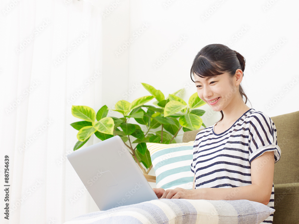 ノートパソコンを使う女性　笑顔