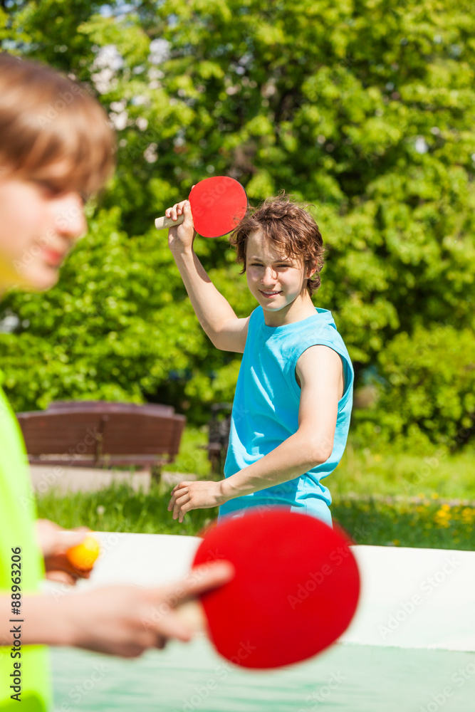 两个微笑的朋友一起打乒乓球