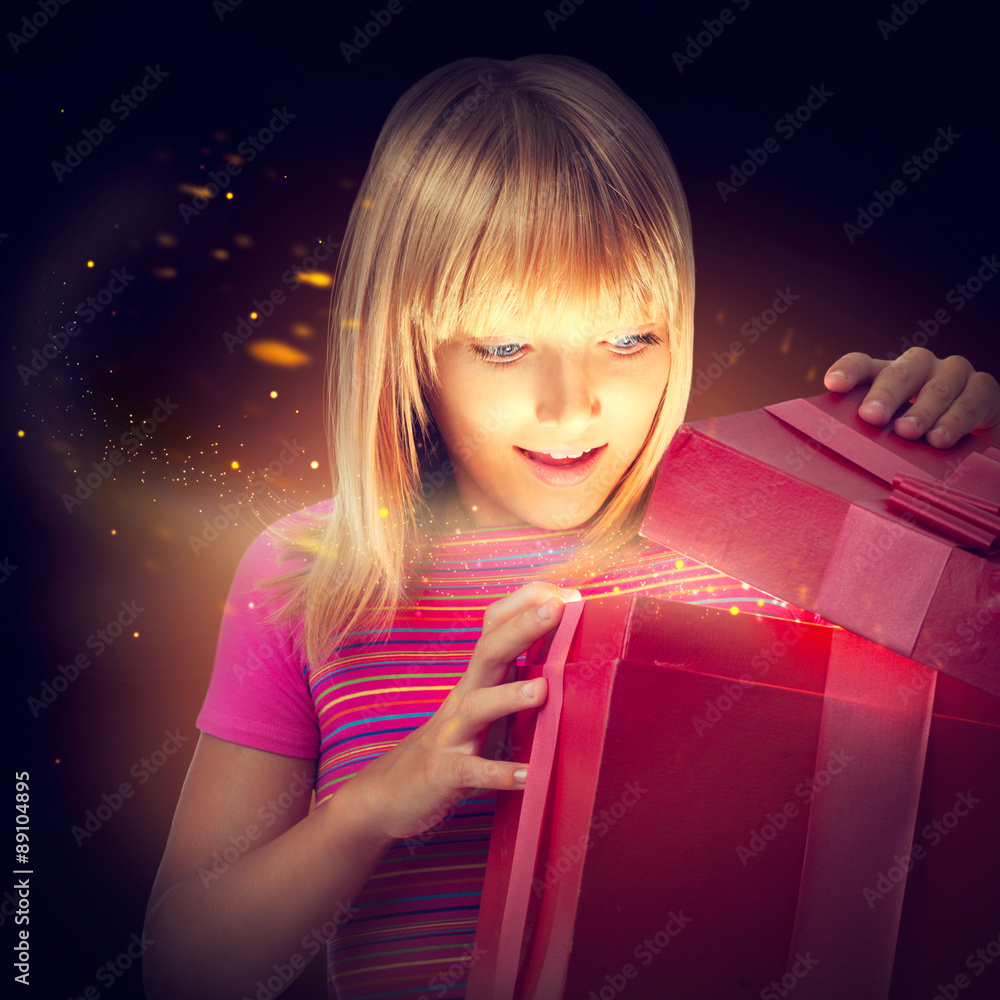 给孩子一个惊喜的礼物盒。快乐的小女孩打开礼物盒
