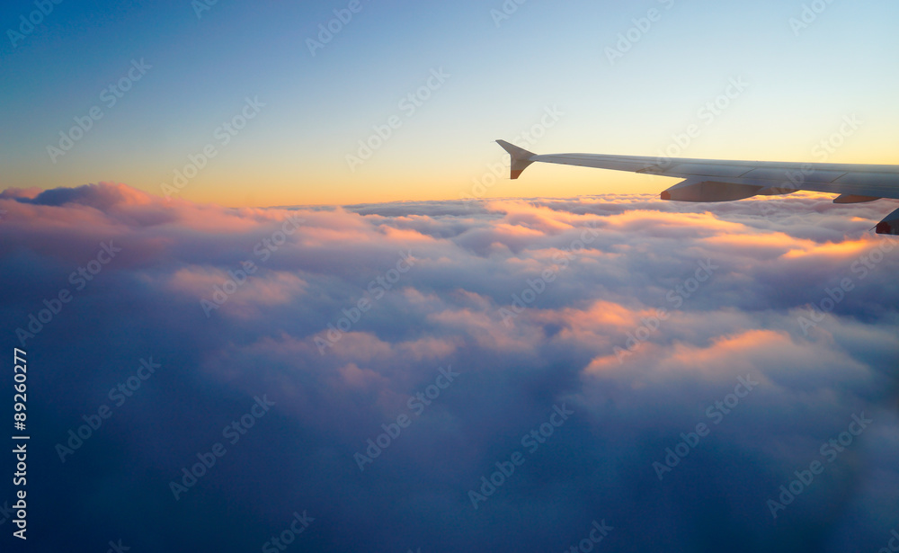 日落天空中从窗口起飞的飞机机翼