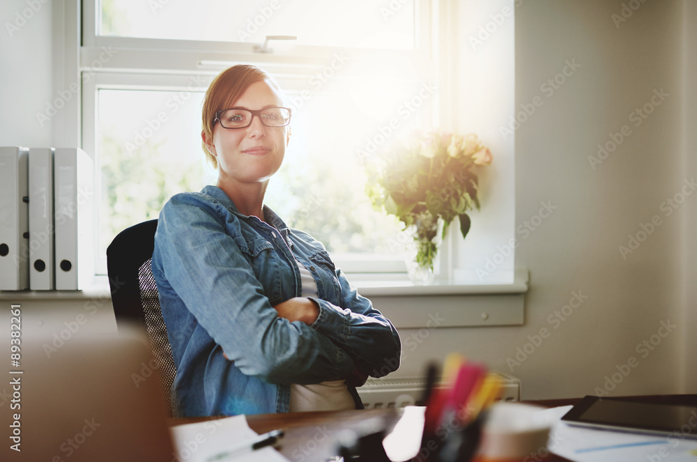 自信的办公室女人坐在办公桌前