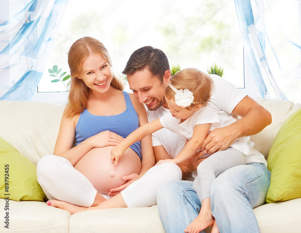 happy family. pregnant mother, father, and child daughter at hom