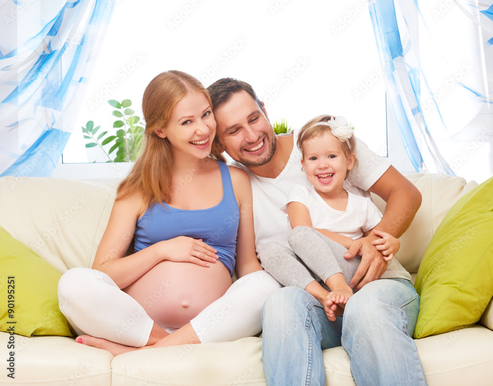 幸福的家庭。怀孕的母亲、父亲和孩子的女儿