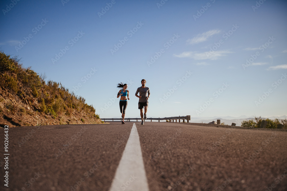 Joggers jogging together on country road