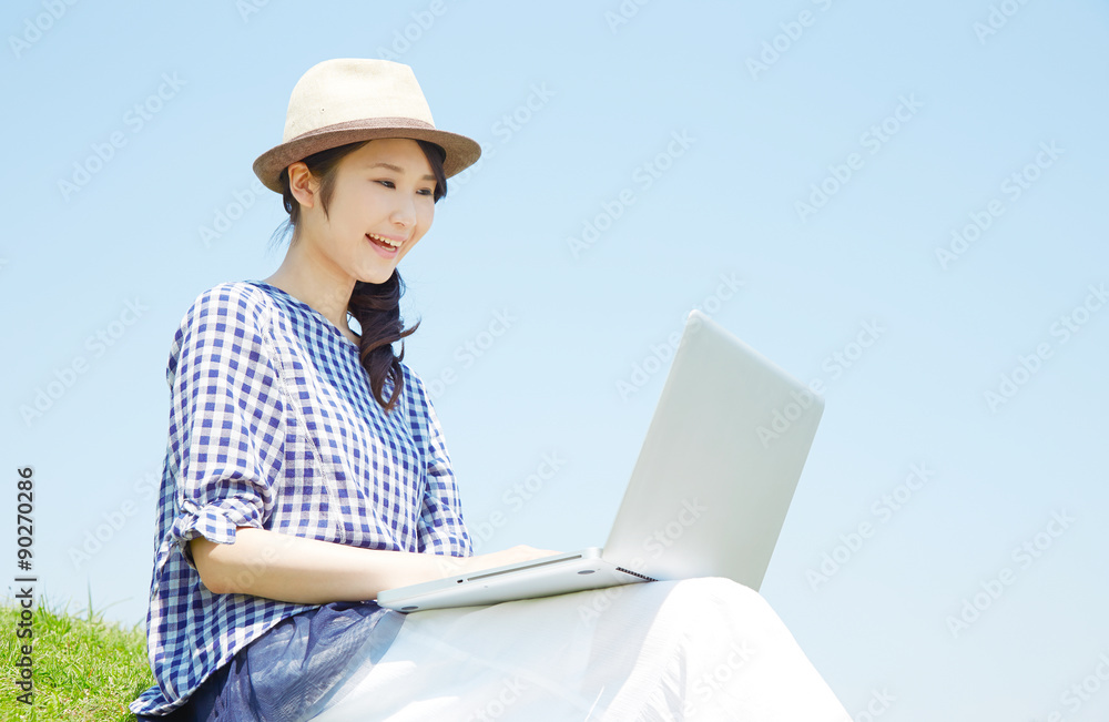 丘でノートパソコンを使う女性