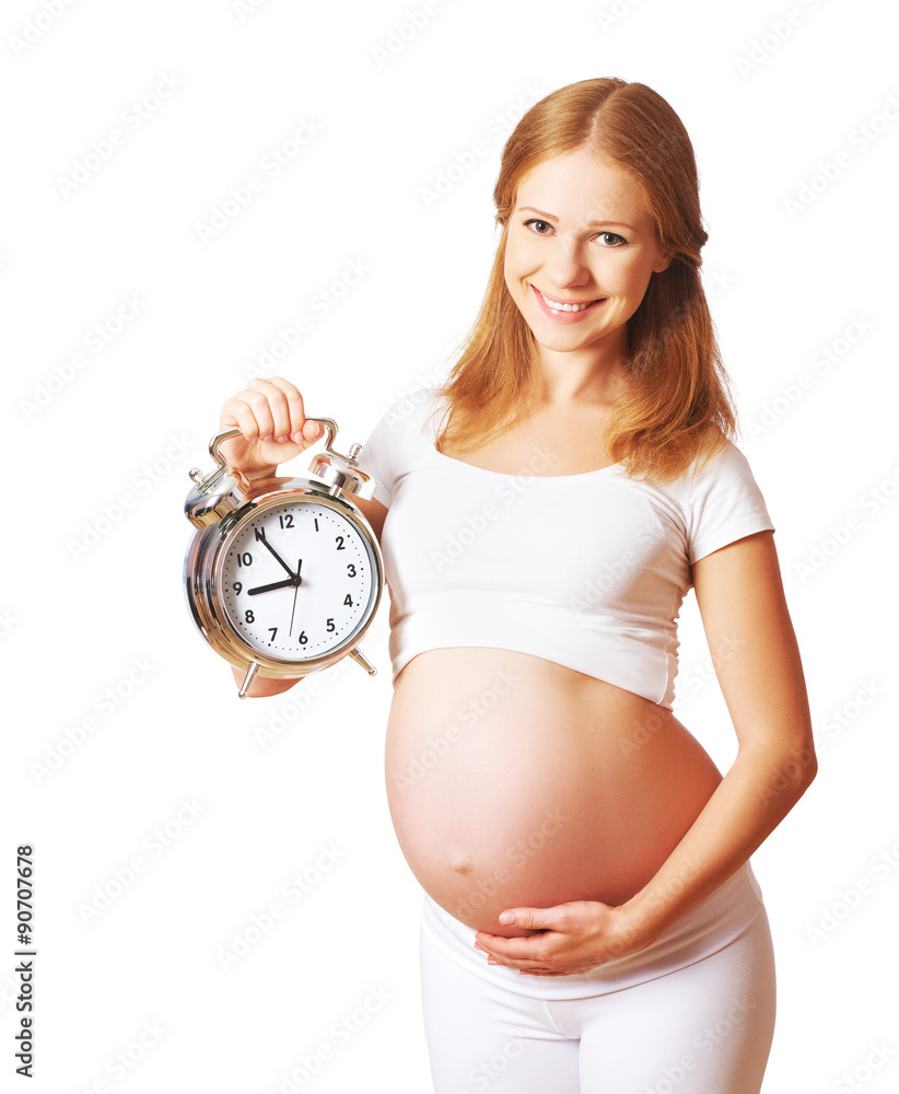 怀孕的概念。孕妇和白巴上的闹钟