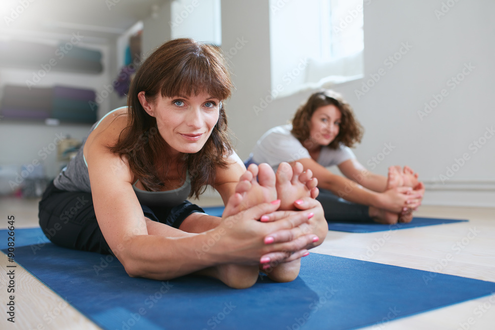 Women doing paschimottanasana yoga pose