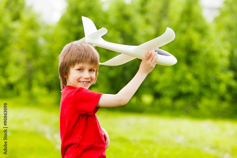 微笑男孩独自拿着白色飞机玩具