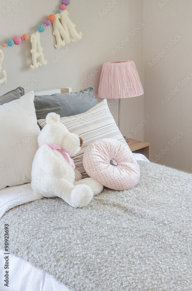 kids bedroom with pillows and dolls on bed