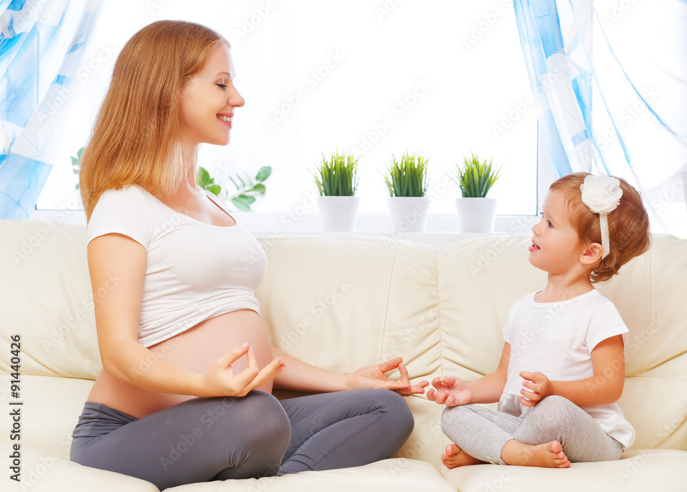 幸福的家庭。怀孕的母亲和孩子女儿瑜伽，放松我