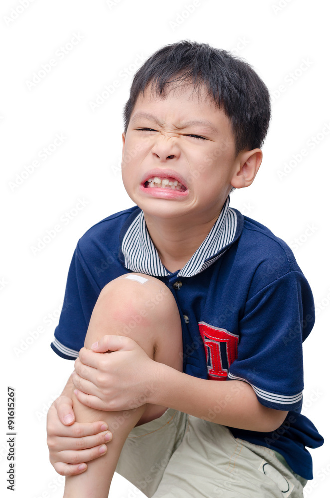 亚洲男孩膝盖被石膏覆盖在白色背部，膝盖受伤