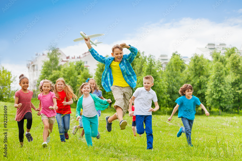 抱着大飞机玩具和孩子的跳跃男孩
