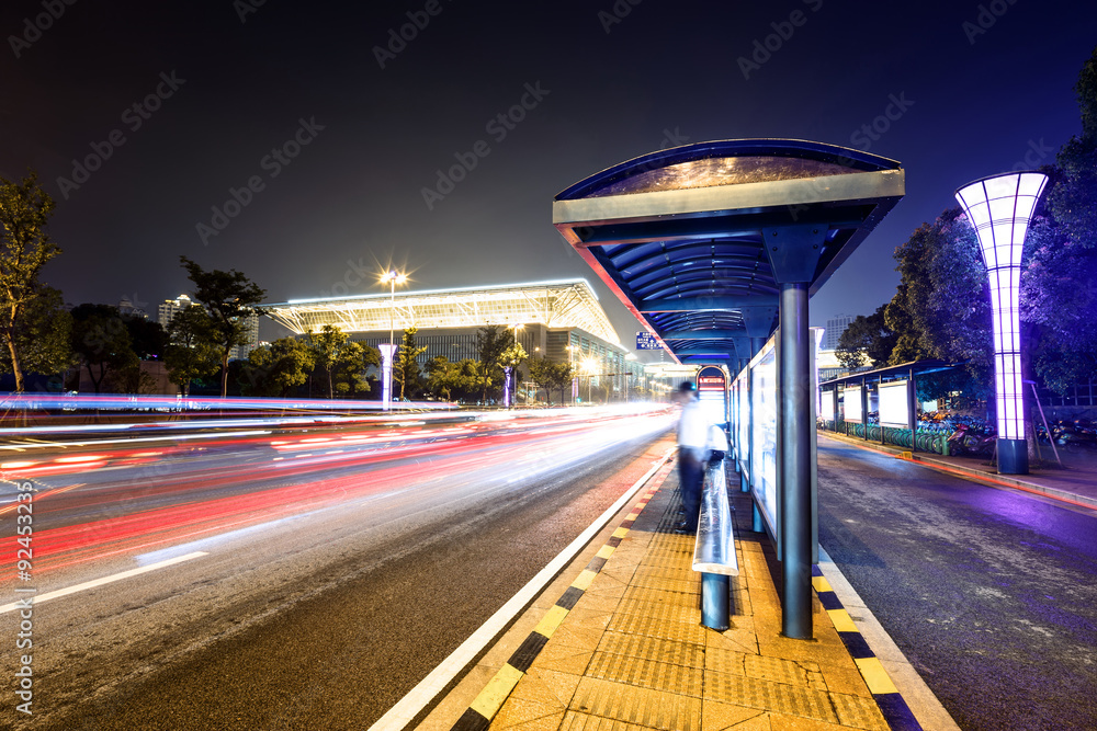 bus station next to a road at night