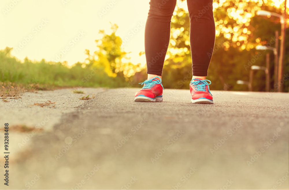 穿着跑鞋的女运动员准备在森林小路上跑步
