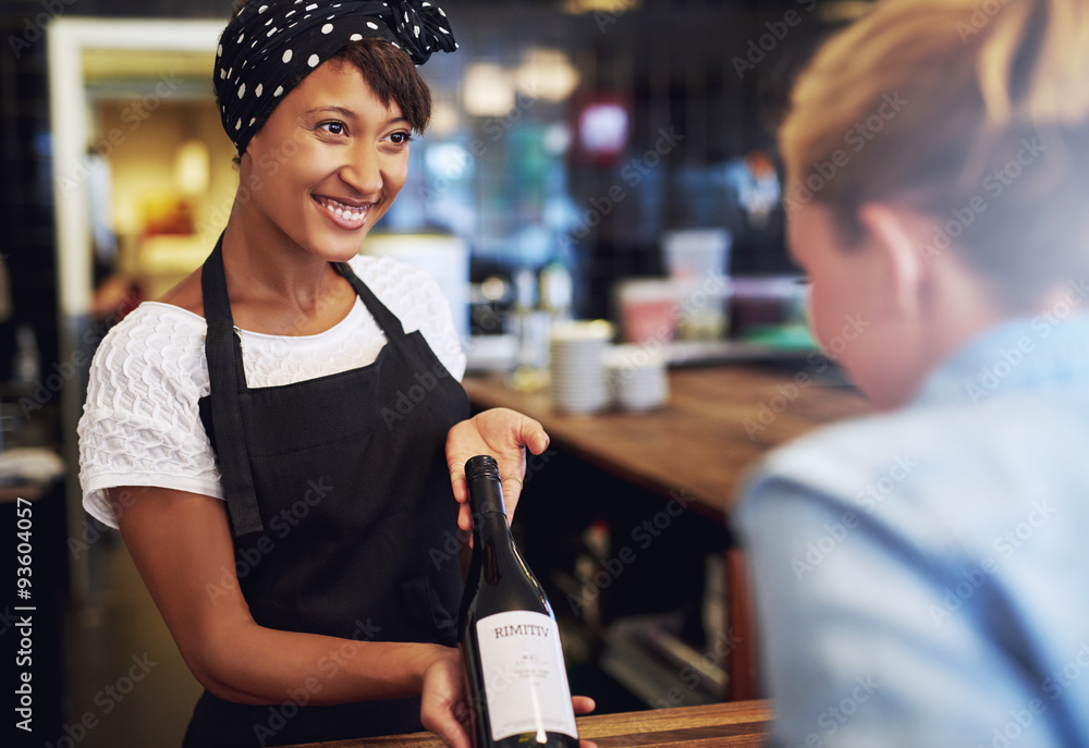 微笑的女服务员或调酒师展示红酒