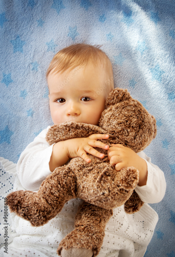 One year old baby holding a teddy bear