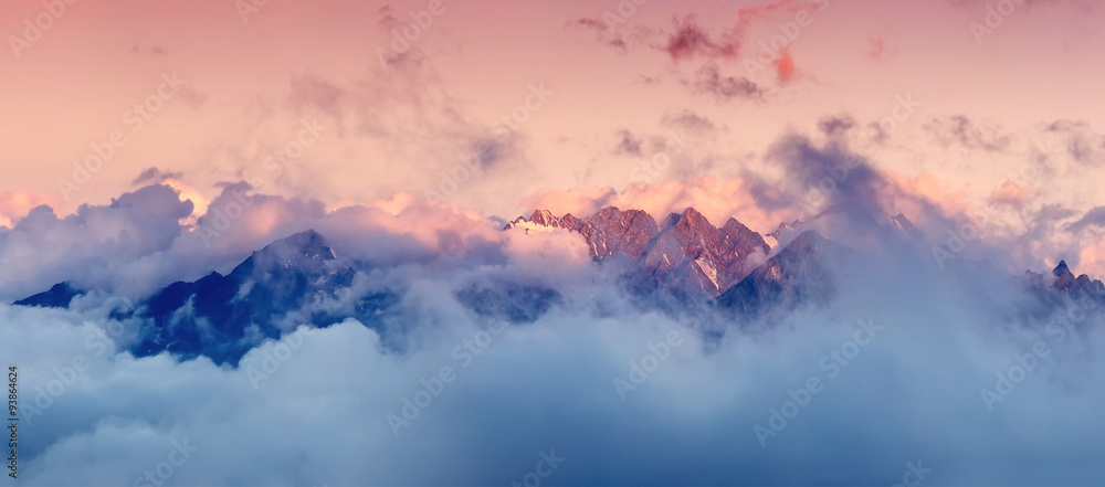 日出时云雾中的高山山脉。美丽的全景景观