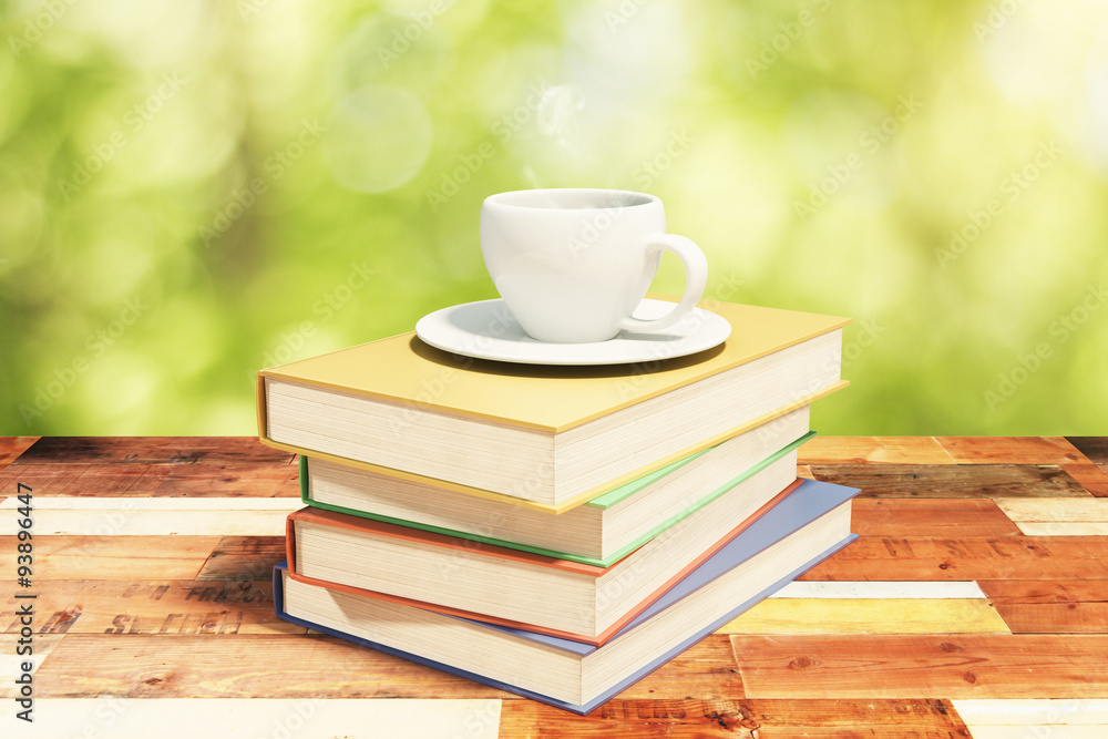 Stack of books on a vintage wooden table with cup of coffee in n