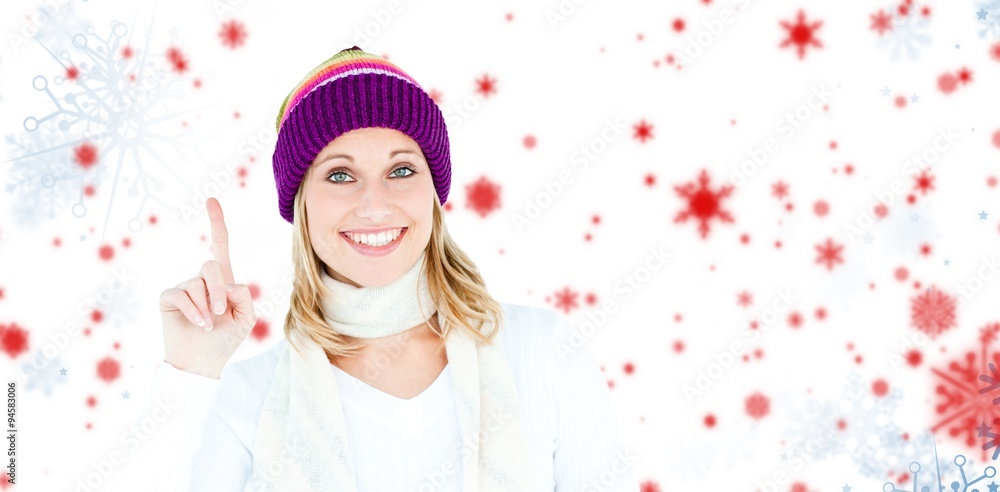 Composite image of joyful woman with a colorful hat pointing up
