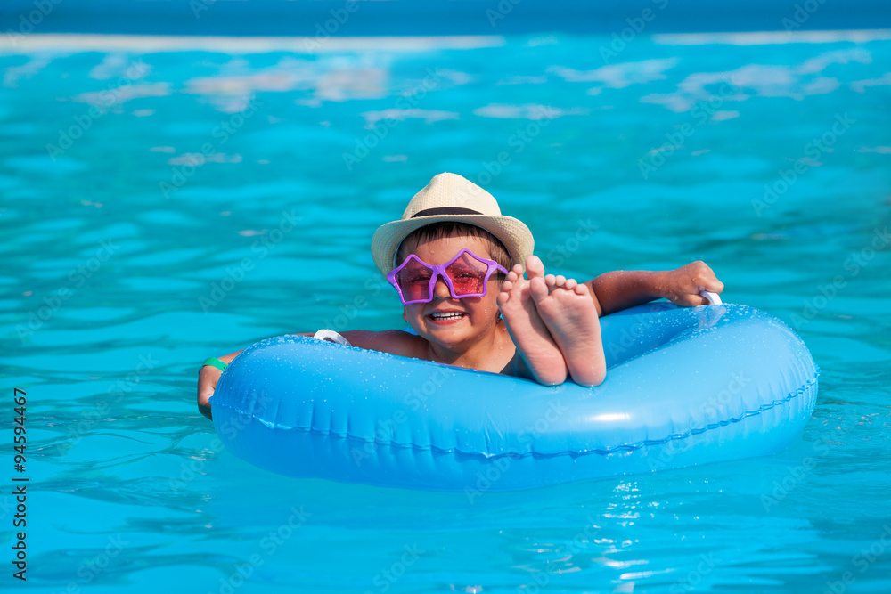 戴帽子、戴眼镜的男孩在充气环游泳