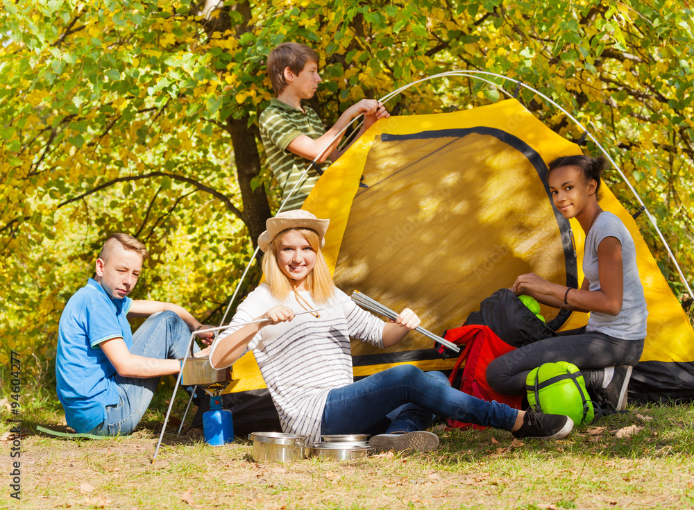 青少年在秋季搭建黄色帐篷