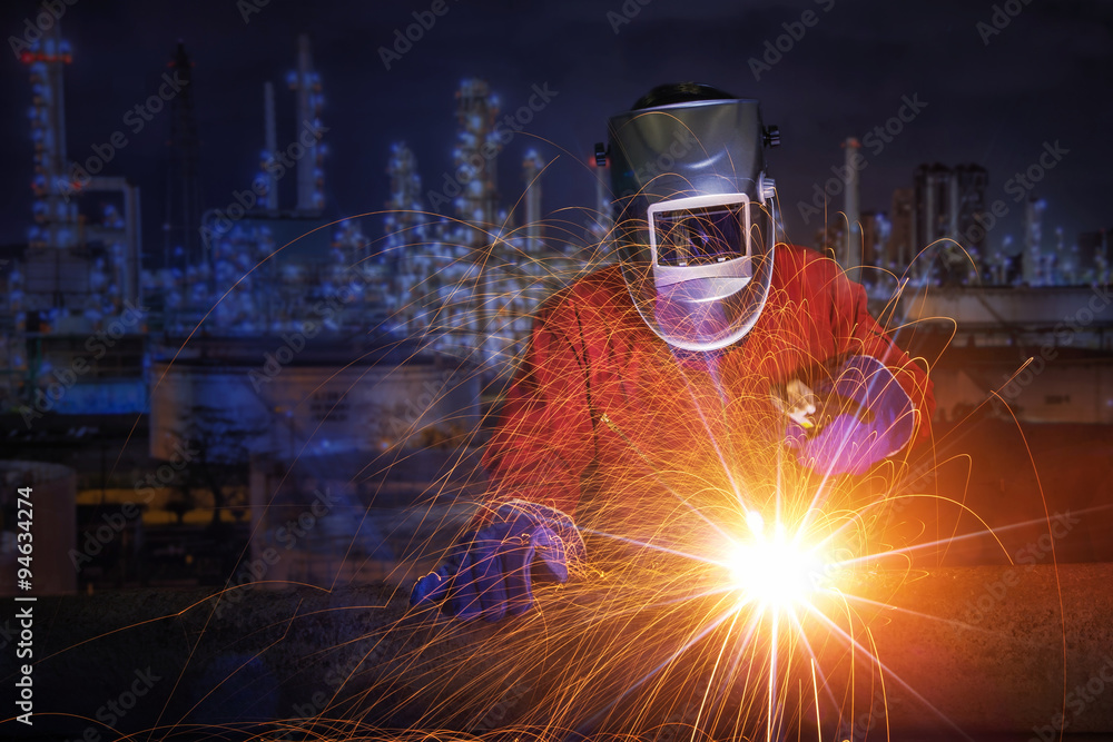 戴防护面罩的工人焊接金属和火花