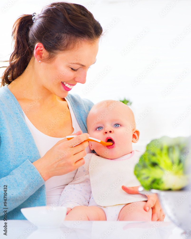 妈妈用勺子喂她的女婴。婴儿食品