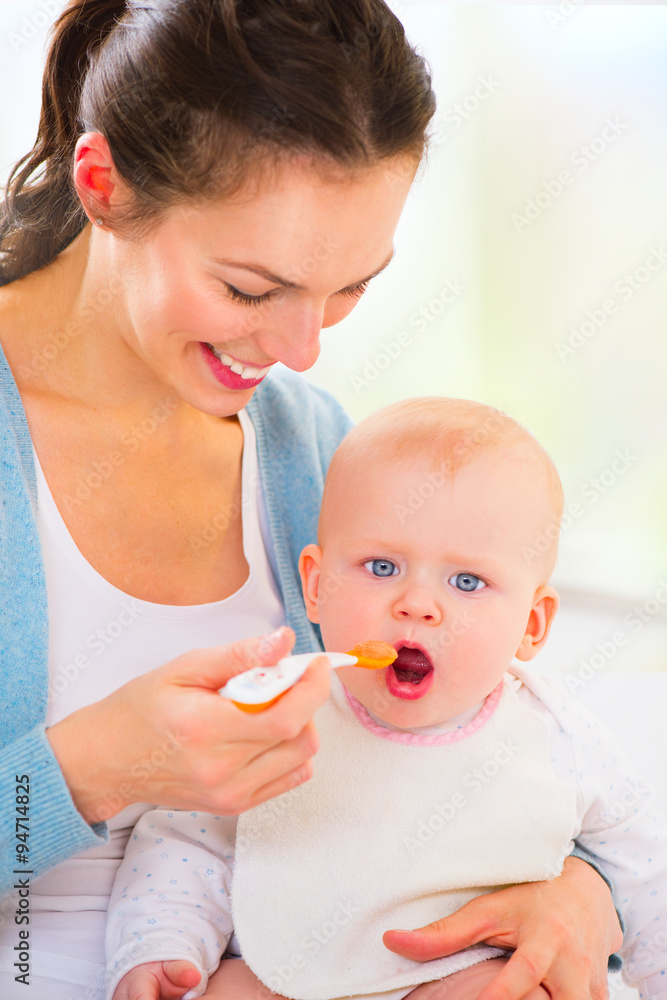 母亲正在喂养她的女婴。婴儿食品