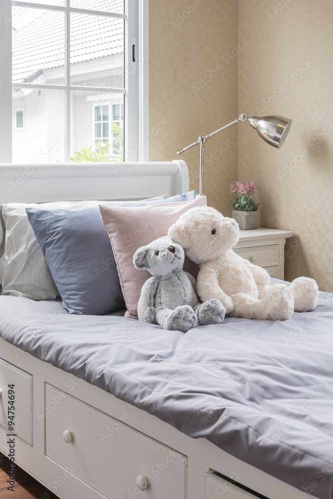kids bedroom with dolls on white wooden bed