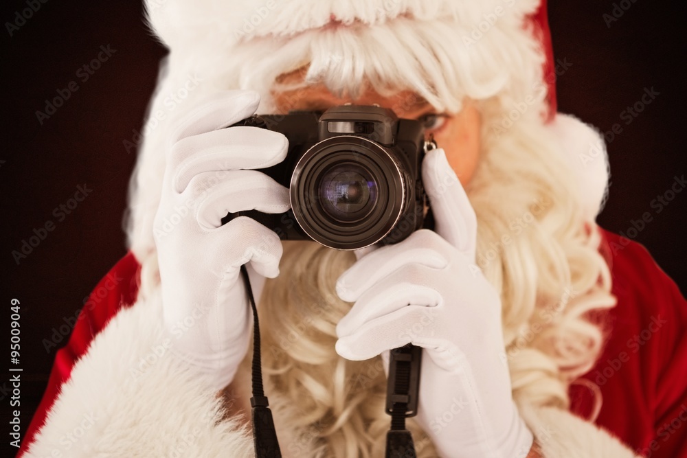 Composite image of portrait of santa taking a photo