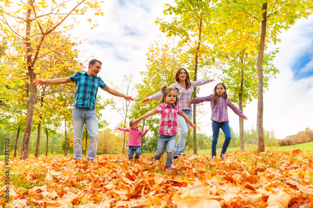 有很多孩子的家庭在秋季公园跑步