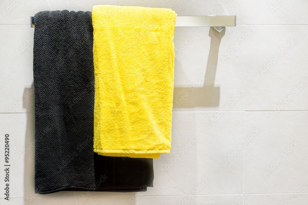 Black and yellow towel on hanger in bathroom