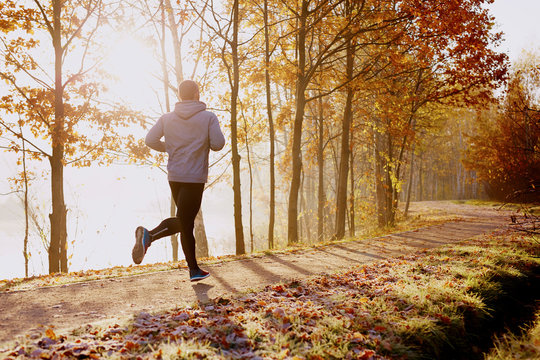 秋天的早晨，男人在公园里跑步