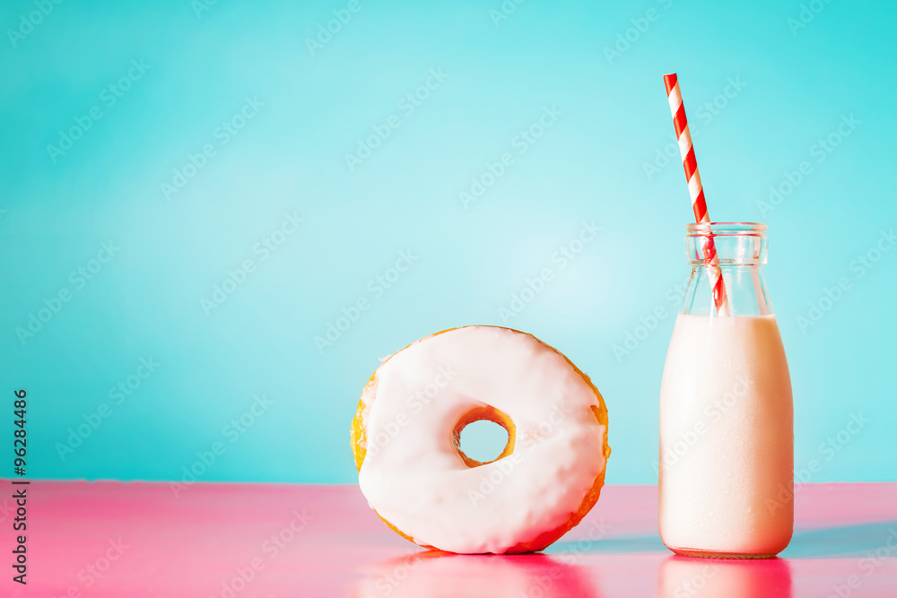 淡蓝色和粉红色背景的牛奶甜甜圈