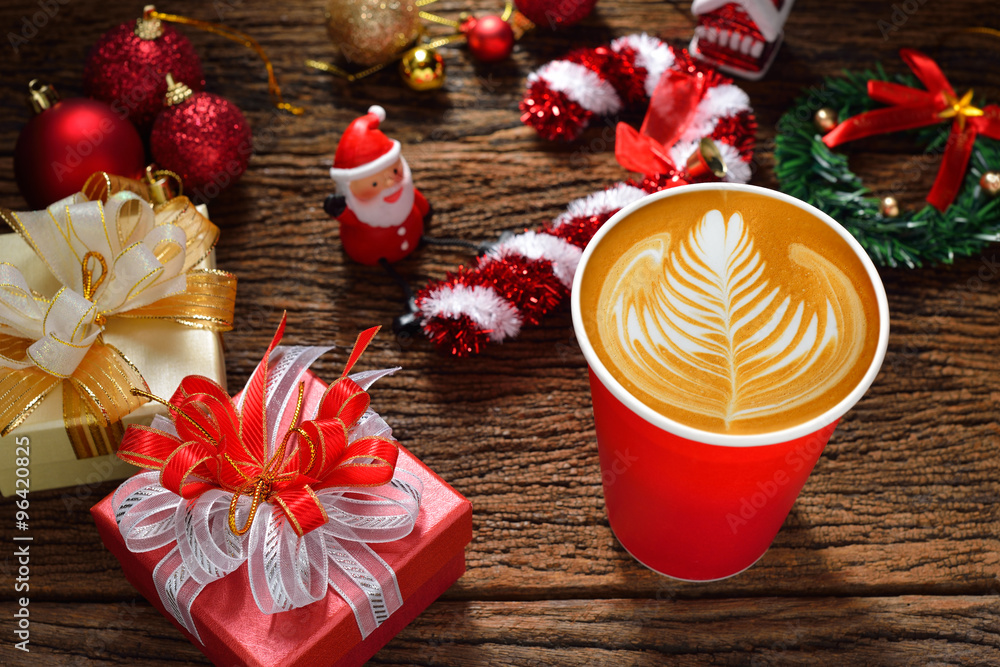 拿铁艺术，木制背景上围绕着圣诞装饰的咖啡拿铁纸杯