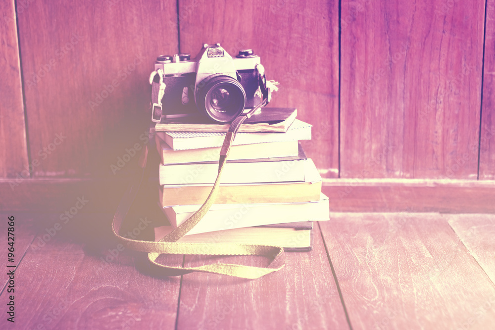 木地板上一堆书上的旧相机，instagram照片效果