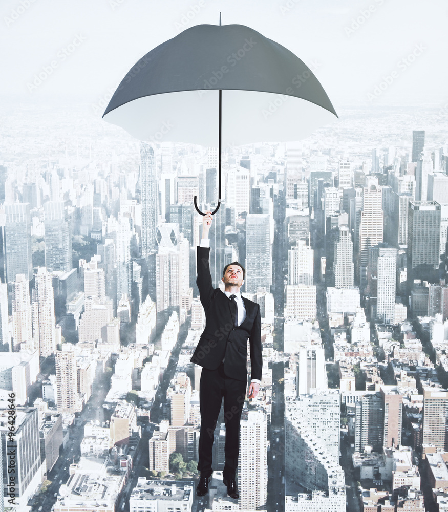 Flying businessman with umbrella at megapolis city background